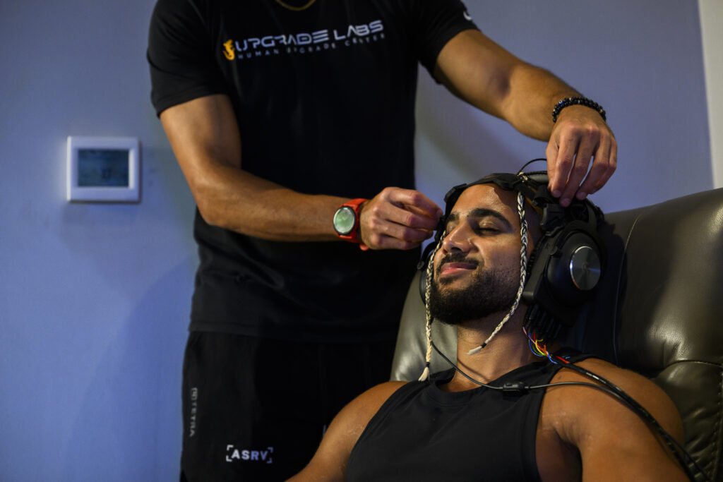 Upgrade Labs staff member placing a Brain Upgrade headset on a man