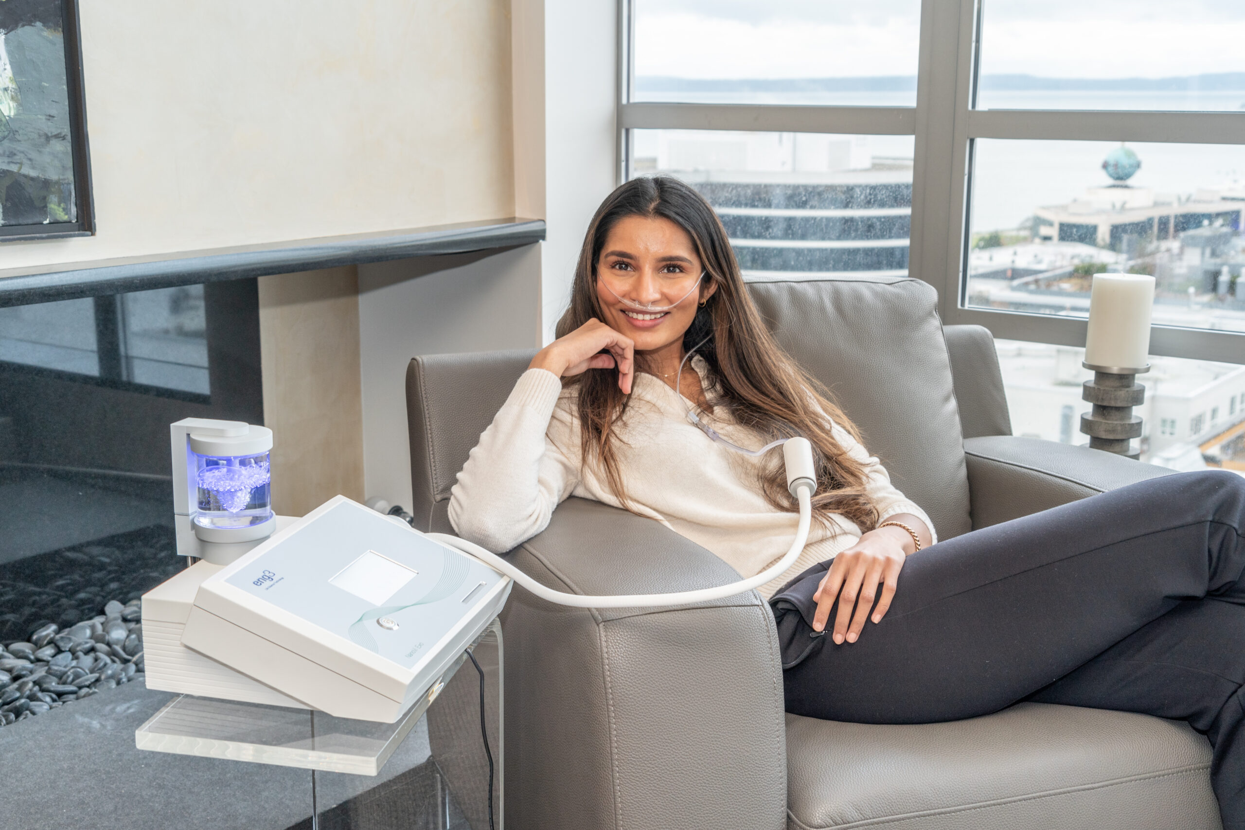 Woman sitting comfortably on a couch, smiling during a NanoVi session