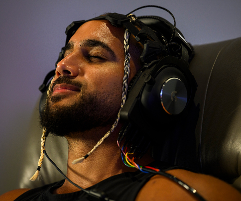 Man of color relaxing with headphones on.